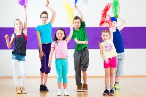 Children dancing modern group choreography with scarfs